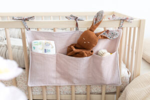Das Bild zeigt ein Nähbeispiel aus rosafarbenen Cordstoff für eine Babybett Aufbewahrung zum Aufhängen nach der kostenlosen Nähanleitung von make it yours the label